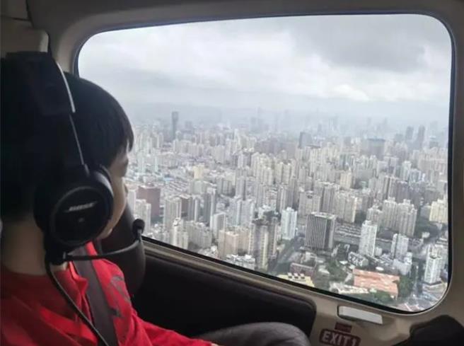 十一假期文旅新亮点赛事旅行、县域旅行火了。图为 10月1日上海新空直升机公司新增黄浦江低空旅游项目一男孩欣赏窗外风景。（大陆央视）  