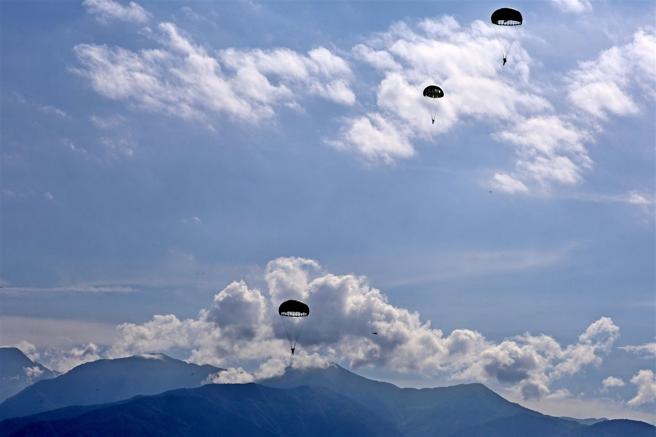  綠色傘花在耀眼陽光和蔚藍天空下綻放，襯托著大武山雄壯的山勢，形成壯觀的景色。（記者孫建屏攝）