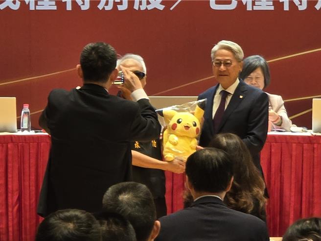 台新金股东临时会今日登场，小股东送上皮卡丘给董事长吴东亮帮其打气。（黄琮渊摄）