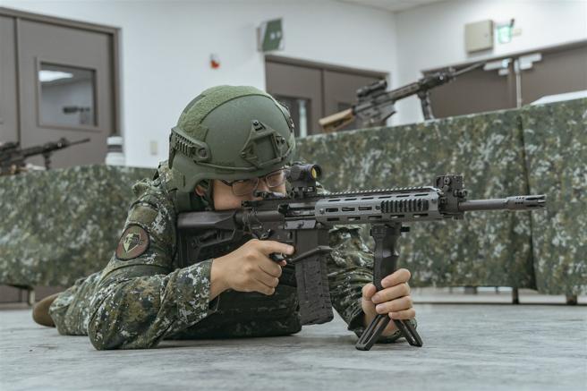 現場說明官進行立、臥、跪等射擊姿勢示範。（記者陳怡璿攝）