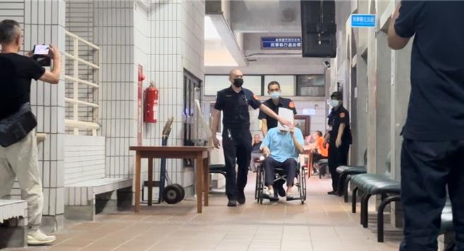 台中市前刑警大队长林明佐遭检方以涉嫌泄漏侦查秘密、收贿及财产来源不明等罪嫌提起公诉，台中地院9日开程序准备庭审理，林明佐坐轮椅、拿文件资料挡住脸进入法庭。（冯惠宜摄）