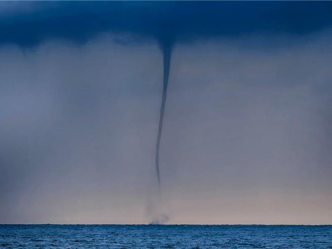 屏東縣離島小琉球9日下午3時許出現罕見的「水龍捲」異象，可清楚看到在蛤板灣外海有條清晰的線與雲層相接、一直下延至海面。（陳姓居民提供／謝佳潾屏東傳真）