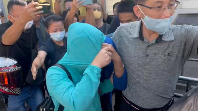 26岁许姓上兵在空军清泉岗基地打靶训练时，疑因枪托撞击地面击发子弹身亡，检警9日进行相验，相验结束许妈妈以衣遮脸，随后搭车离开。（冯惠宜摄）