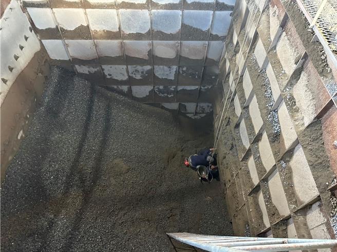 雲林縣斗六市1家製造水泥電桿公司10日發生移工掉落沙石坑，由於沙石坑深達約10米，移工整個人沒入砂石中，僅露出頭部，縣消防局搶救中。（民眾提供／張朝欣雲林傳真）