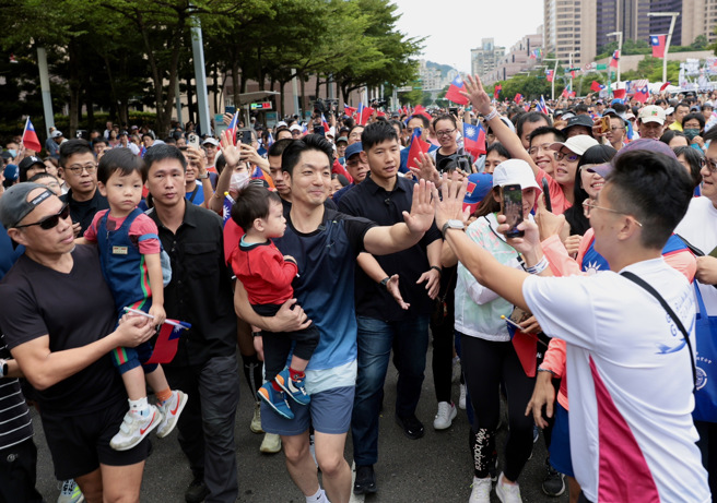图为台北市政府10日在市民广场举办「中华民国113年国庆升旗暨庆祝活动」，以「龙庆双十臺北应援」为主题，除升旗典礼仪式外，更举行特色慢跑；臺北市长蒋万安（中）抱着儿子领跑并与市民开心击掌。（资料照／郭吉铨摄）