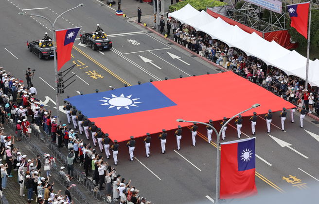 113年中华民国国庆大会10日盛大登场，陆军官校国旗队举着巨幅国旗通过观礼台。（刘宗龙摄）
