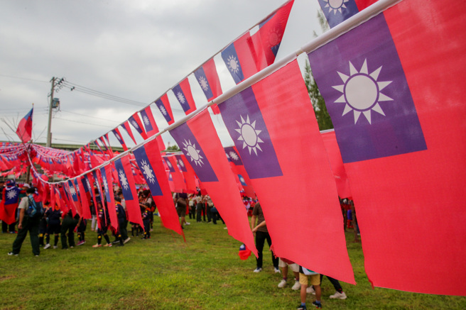 雙十國慶日將至，桃園市平鎮高齡84歲的國旗屋老闆張老旺，今年連續第30年自掏腰包舉辦國慶升旗典禮，受去年拔旗事件影響，今年移師龍岡圓環旁新落成公園舉辦，龍岡圓環現場還有復刻版的國軍與軍車，讓現場民眾排隊合照。（陳麒全攝）