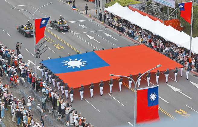 113年中华民国国庆大会10日盛大登场，陆军官校国旗队举着巨幅国旗通过观礼台。（资料照,刘宗龙摄）