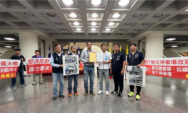 台北市政府欲将黎元停车场改建为殡葬大楼，地方民眾强烈反对，周边的4名里长在当地国民党议员曾献莹的陪同下，在台北市议会大厅拉布条抗议。（丁上程摄）