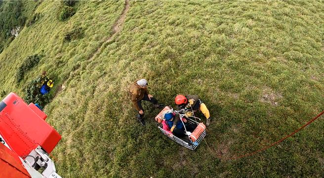 黑鹰直升机执行干卓万山难救援任务，起初云雾拢盖，于空中盘旋约7分钟云雾散去，才发现患者，将患者吊挂上机。（空勤总队提供／杨静茹南投传真）
