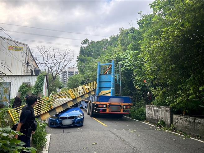 聯結車載運的貨物超過限高，導致標示桿被撞斷掉落。（警方提供）