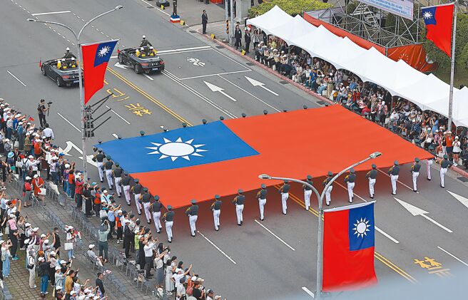 113年中华民国国庆大会10日盛大登场，陆军官校国旗队举着巨幅国旗通过观礼台。（刘宗龙摄）