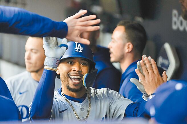 道奇貝茲（中）G4率先開轟後回到休息室與隊友擊掌慶祝。（美聯社）