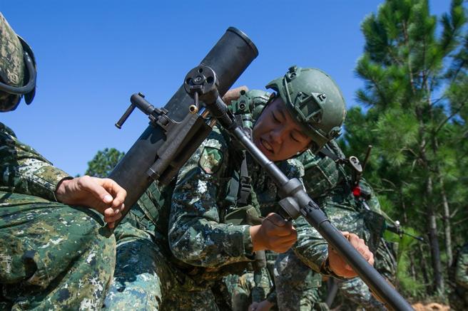  義務役役男搖動方向機與高低機，準確調整各項參數，模擬演練射擊。（記者林睿奕攝）