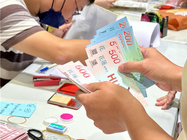 花蓮縣府今起發振興券，民眾當面點收振興券張數。（王志偉攝）