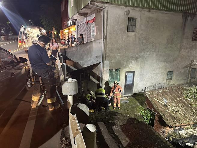 卢姓骑士摔落路边边坡，警消抢救中。（淡水警分局提供）