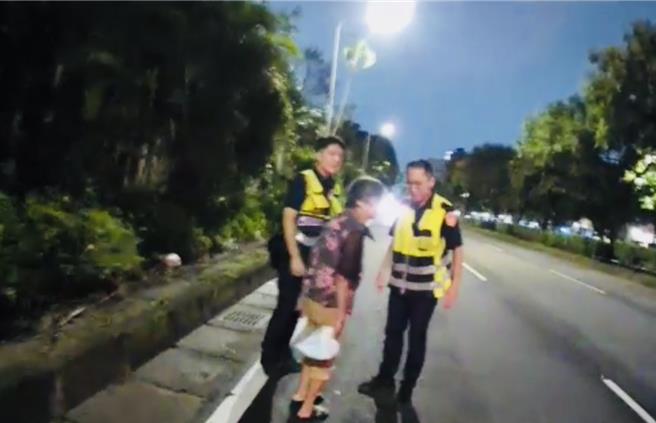 保大员警赶紧将妇人带到安全地区，并协助其返家。（翻摄照片／林郁平台北传真）