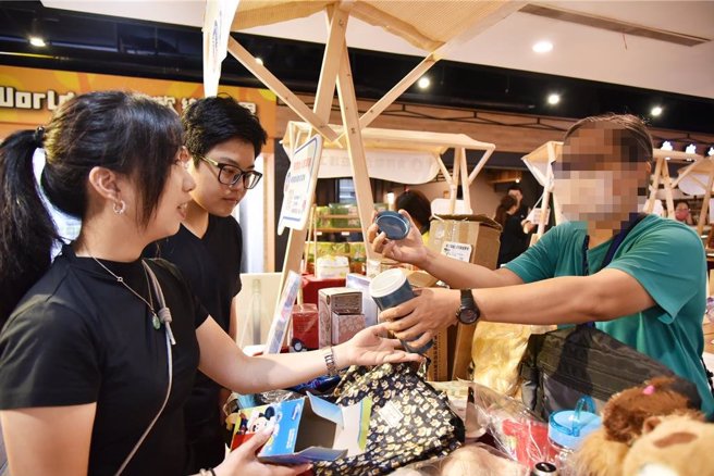 小玉在摊位前向民眾介绍自家二手商品，显得有自信。（廖素慧摄）