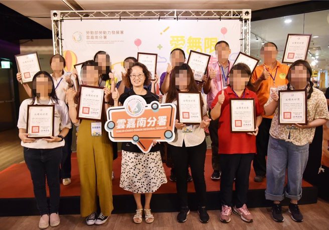 云嘉南区庇护工场成果展，劳动部云嘉南分署副分署长许慧香（左三）为伙伴们加油打气。（廖素慧摄）