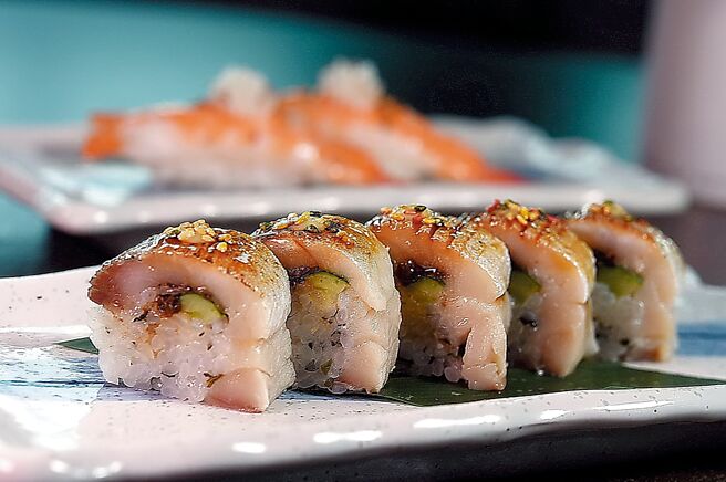 〈炙烧鲭鱼棒寿司〉以醋渍鲭鱼搭配醋饭，卷入寿司姜、海带芽、小黄瓜、紫苏叶，并以有马山椒与白芝麻提升寿司饭的风味。出餐前轻炙表面，香气四溢。图／姚舜