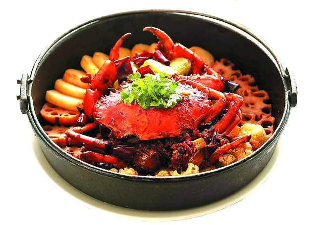 北投大地酒店〈奇岩一號〉的川味〈乾鍋大沙公〉，鍋內除沙公外，並有爽脆的蓮藕片與白花椰菜。圖／業者提供