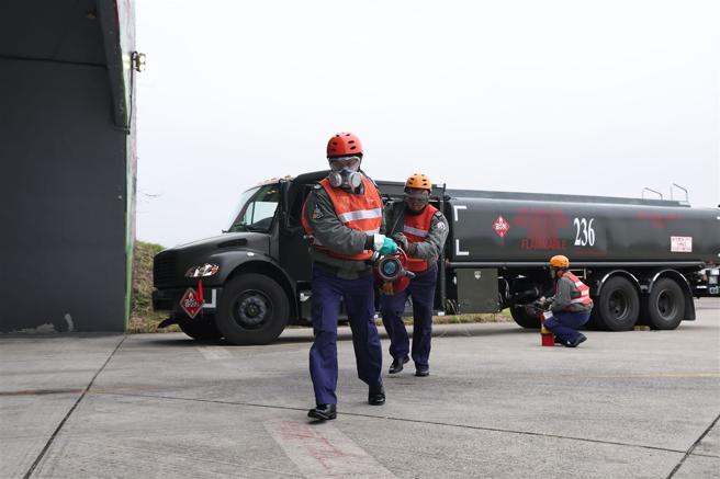 補給中隊官兵合力抬起20公斤油管，實施油料補給作業。（記者黃迪明攝）