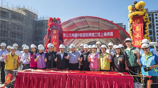 新竹县政府投入11.54亿元兴建的竹北市文兴国中，第2期工程将完成，13日热闹举办上梁典礼，副县长陈见贤（中）指县府在高铁特定区兴建3所国小和2所国中，将完成「最后一块拚图」。（罗浚滨摄）
