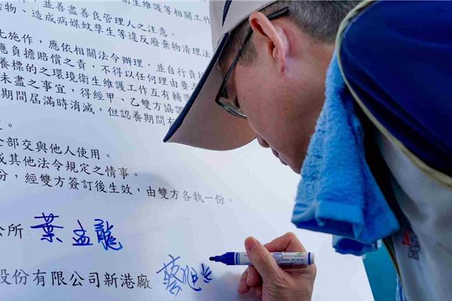台化公司資深經理蔡旭輝代表簽下「三角公園」認養同意書。(新港鄉公所提供／呂妍庭嘉義傳真)