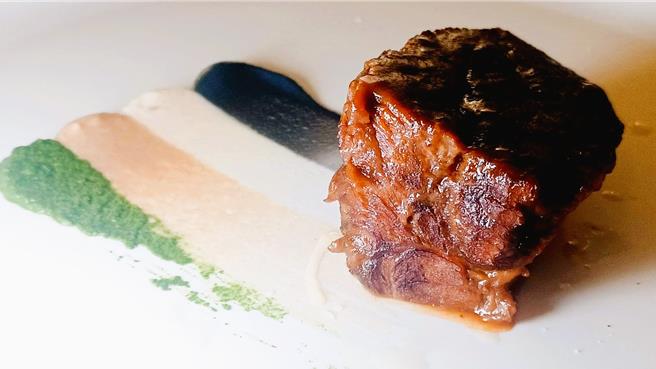 「海洋珍珠宴」热前菜「勃根地炖牛颊」，盘饰以竹炭蒜香巴萨米克醋、白花菜、咖啡洋葱、松子皇宫菜创意呈现海洋拉娜品牌色彩。（陈韵萍摄）