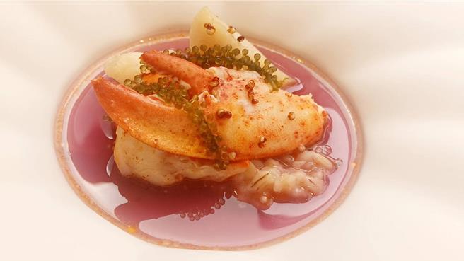 「慢火烤波士顿龙虾、蔬菜精华液」，缀以由番茄、红萝卜、西芹、月桂叶等熬制的蔬菜精华高汤，主厨以西餐罕见的红凤菜天然调色，浅紫色高汤视觉高贵。（陈韵萍摄）