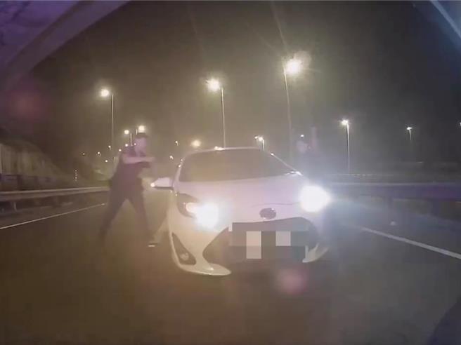 警方在國道三號中寮段攔下逆向行駛的巫姓女子，持槍喝令她下車。（民眾提供／郭良傑高雄傳真）