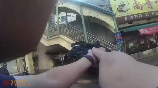 警方下車開槍阻止嫌犯再度衝撞，一名嫌犯腹部中槍。（翻攝畫面）