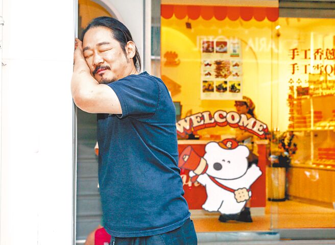 金度潤在「甜堂」店門口擺出可愛的瞇眼POSE接受專訪。（粘耿豪攝）