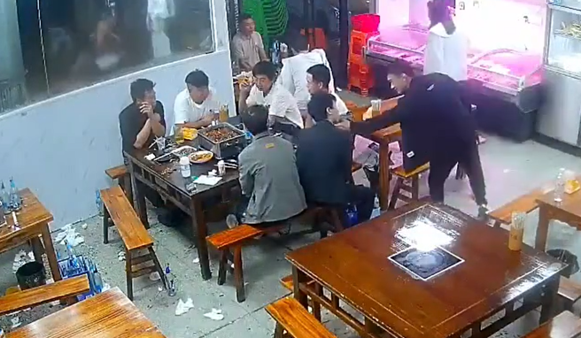 1名男子疑似不滿女友人的黑絲長腿被隔壁桌的黑衣男偷瞄，他獨自一人竟大膽地到隔壁桌挑釁。（翻攝自微博）