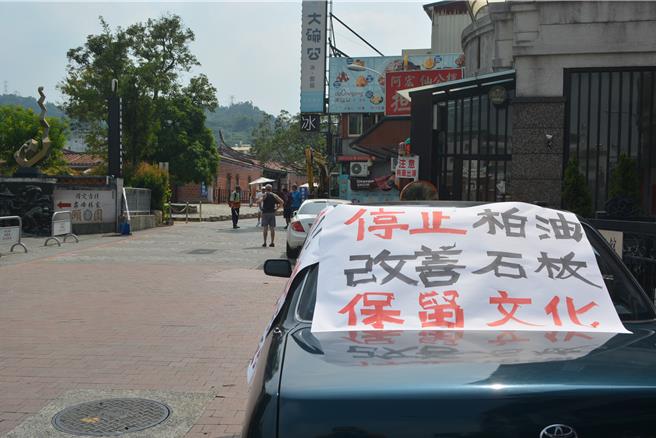 國定古蹟霧峰林家宮保第園區前民生路原是石板鋪面，近年頻頻傳出機車「犁田」事故，地方決議改鋪柏油，10日起進場施作，卻有民眾貼反對鋪設柏油海報。（潘虹恩攝）