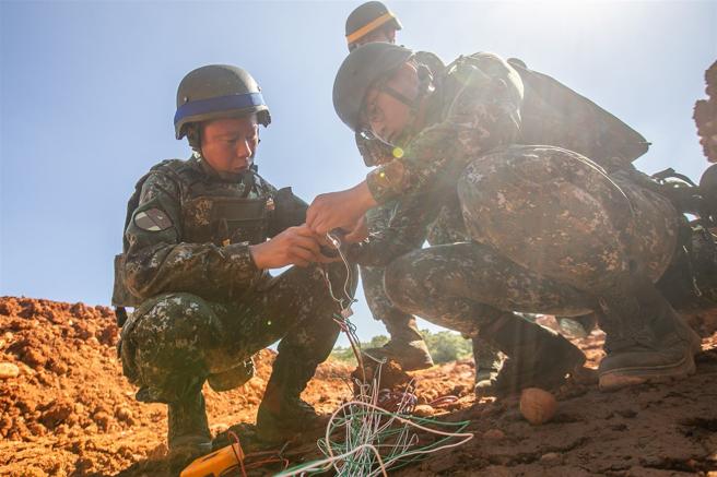  官兵在助教的協助下，使用三用電表檢查導線及電雷管電阻，並進行電雷管與導線勾接，完成埋設作業。（記者林睿奕攝）