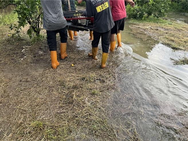 张姓公务员找5个大汉把故障动不了的遥控割草机抬出农园。（民眾提供）