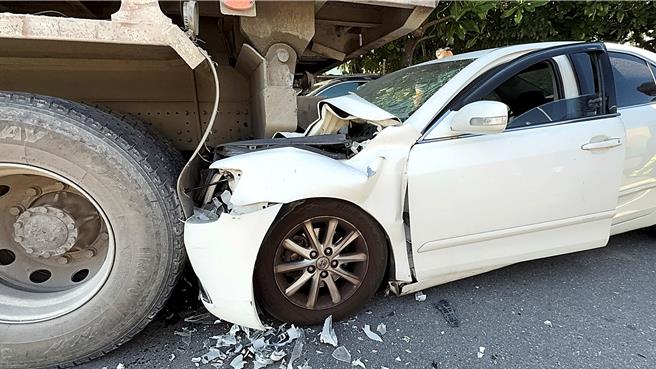 白色轿车自撞路旁砂石车，车头卡入砂石车斗下缘，林姓驾驶昏迷受困车内。（萧嘉蕙摄）