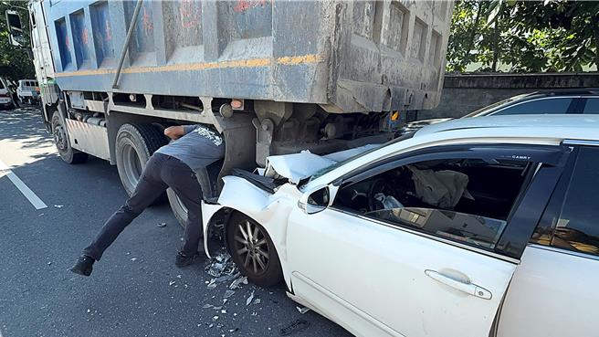 白车轿车驾驶前座被卡死，改由开启驾驶座车门救人。（萧嘉蕙摄）