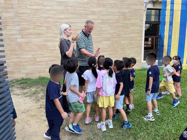 小哈引领父亲奥利佛参观莲潭国中小学校园环境。（校方提供／宝智华台南传真）