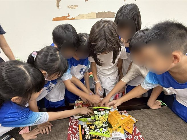 2年2班小朋友们争抢奥利佛带来的德国零食。（宝智华摄）