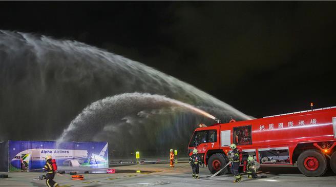 为进一步提升桃园国际机场在灾害抢救中的应变能力，桃园机场公司于16日晚间在第三航厦北侧的机坪举办了「113年度空难灾害防救演习」。此次演习旨在模拟夜间空难情境，共动员22个单位、超过60辆作业车辆及装备，并有200人次参与演习。（陈麒全摄）