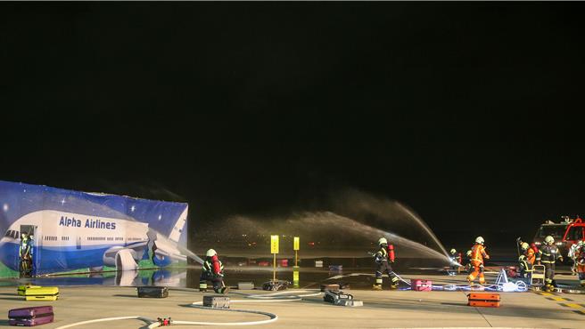 为进一步提升桃园国际机场在灾害抢救中的应变能力，桃园机场公司于16日晚间在第三航厦北侧的机坪举办了「113年度空难灾害防救演习」。此次演习旨在模拟夜间空难情境，共动员22个单位、超过60辆作业车辆及装备，并有200人次参与演习。（陈麒全摄）