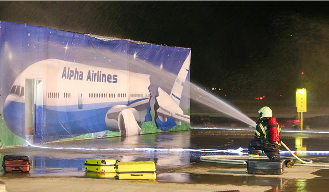 为进一步提升桃园国际机场在灾害抢救中的应变能力，桃园机场公司于16日晚间在第三航厦北侧的机坪举办了「113年度空难灾害防救演习」。此次演习旨在模拟夜间空难情境，共动员22个单位、超过60辆作业车辆及装备，并有200人次参与演习。（陈麒全摄）