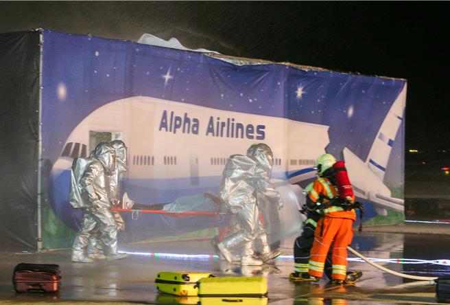 为进一步提升桃园国际机场在灾害抢救中的应变能力，桃园机场公司于16日晚间在第三航厦北侧的机坪举办了「113年度空难灾害防救演习」。此次演习旨在模拟夜间空难情境，共动员22个单位、超过60辆作业车辆及装备，并有200人次参与演习。（陈麒全摄）