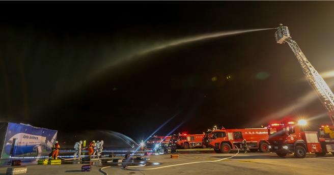 为进一步提升桃园国际机场在灾害抢救中的应变能力，桃园机场公司于16日晚间在第三航厦北侧的机坪举办了「113年度空难灾害防救演习」。此次演习旨在模拟夜间空难情境，共动员22个单位、超过60辆作业车辆及装备，并有200人次参与演习。（陈麒全摄）