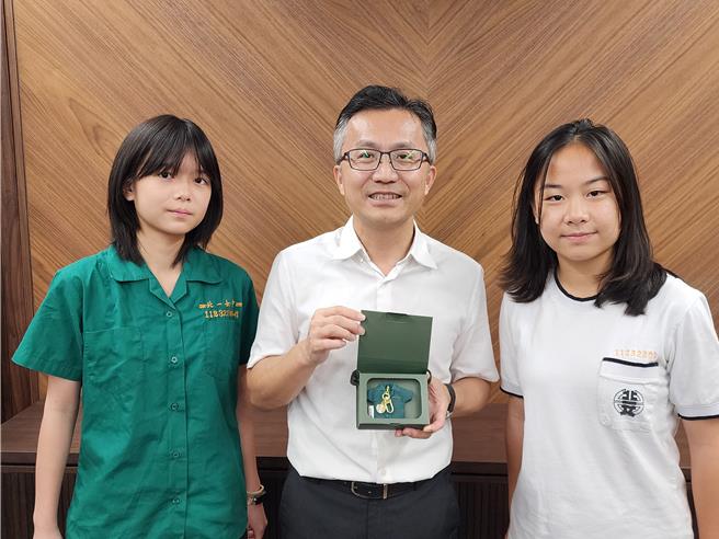 北一女中校长陈智源（中）手持 「北一女中造型悠游卡-永恒校徽款」与北一女中学生班联会代表（左、右）合影，携手推动「北一女中・爱转动」公益活动，收益10％捐给「财团法人台北市政府教育局认助清寒学生基金会」。（台北教育局认助清寒学生基金会提供）