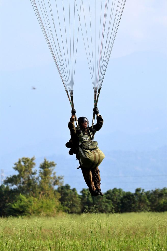 训员在跳伞时，身穿「铁汉装」及携行枪枝、个人装备，考验跳伞技能。（记者孙建屏摄）