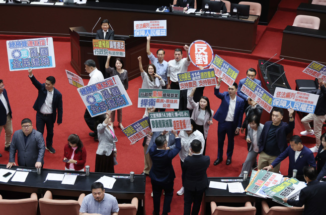 立法院18日院會處理民進黨團提議增列總預算案、前瞻第五期預算案，民進黨立委高舉標語要求審查總預算（左），國民黨立委亦高舉標語要求行政院退回重編（右），最後表決結果贊成49票、反對58票，藍白聯手再度封殺總預算。（姚志平攝）