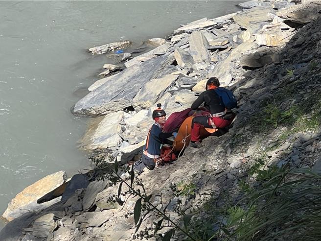 搜救人員將女山友遺體拉上步道，再送往無雙停機坪，運載下山。（南投縣消防局提供／馮惠宜南投傳真）